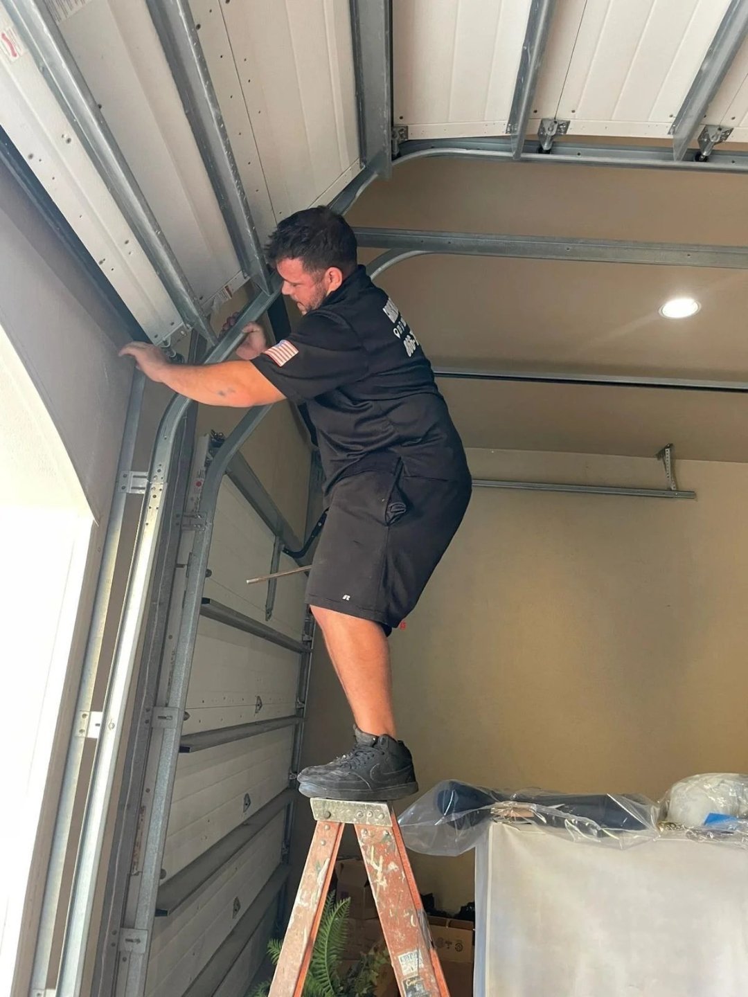 Installer examining the side track from a small step ladder