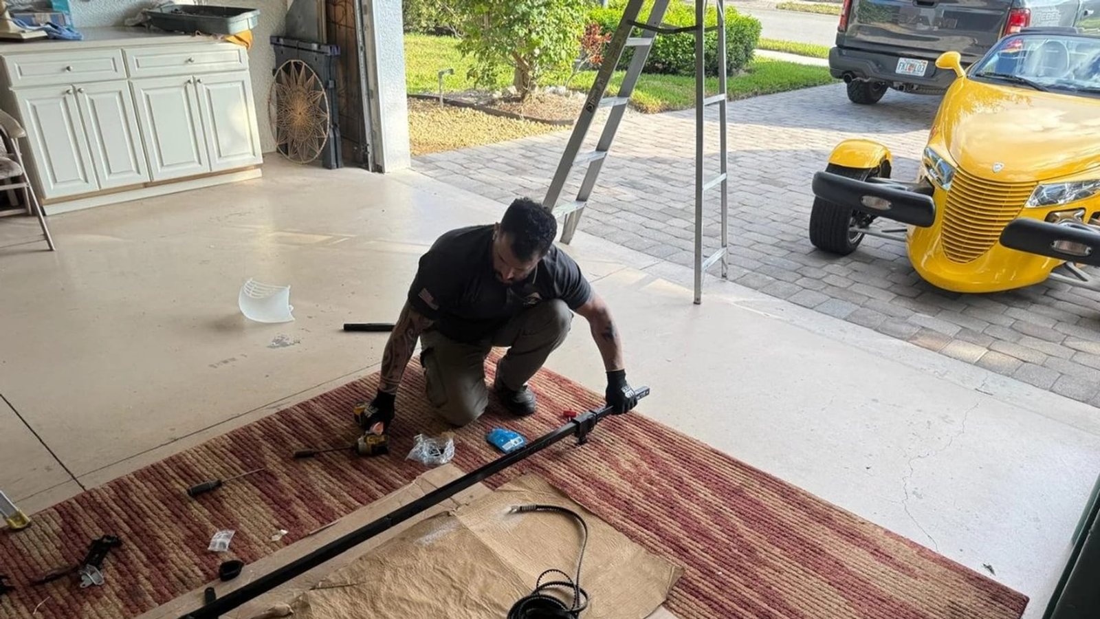 Worker assembling door hardware on a protective floor covering