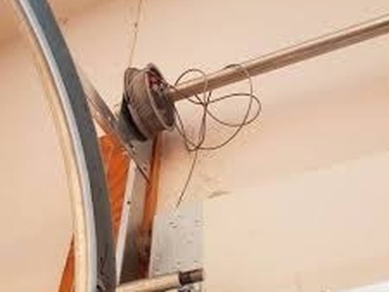 Loose lift cable beside an upper door corner