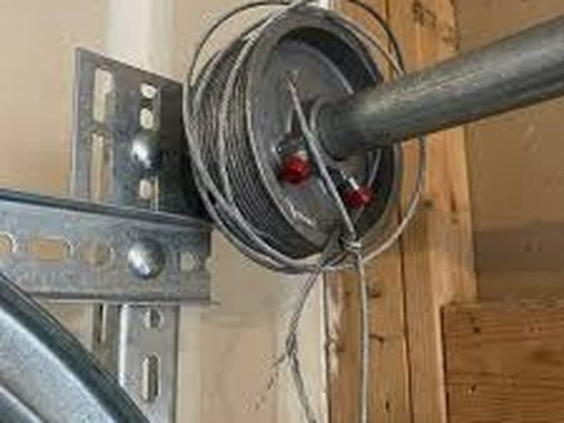 Lift cable drum beside the upper corner of a sectional door
